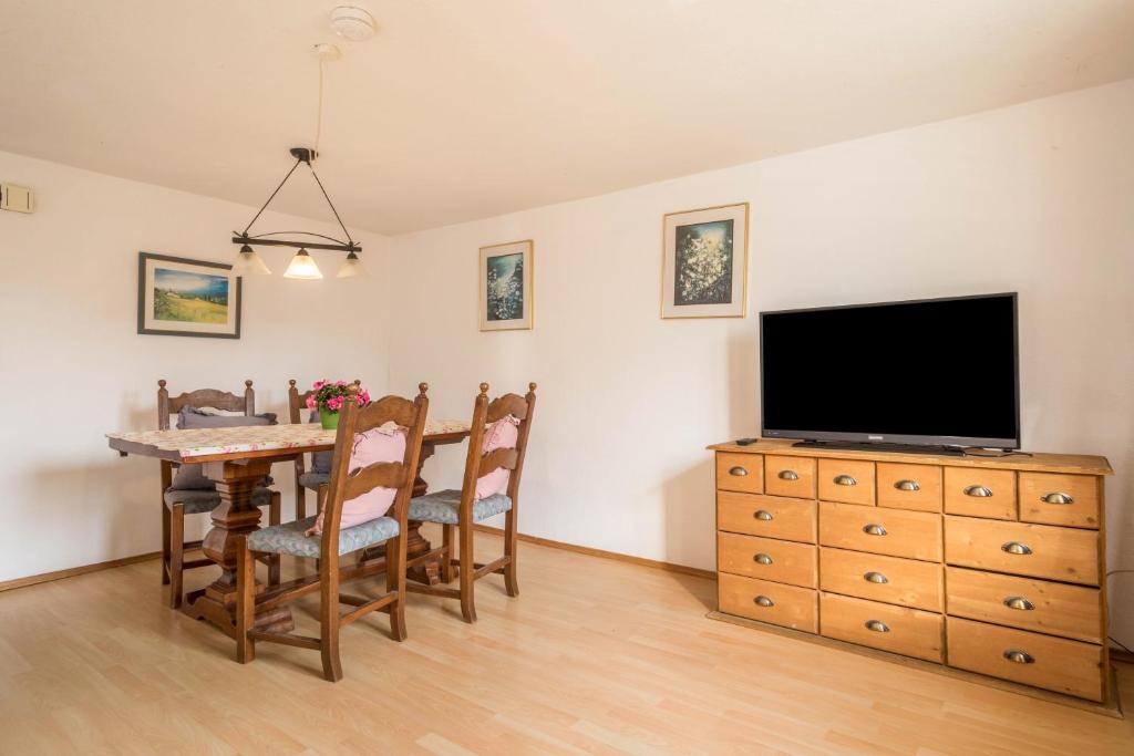 a living room with a dining room table and a television at Ferienwohnung Achraintal 1 in Lindau