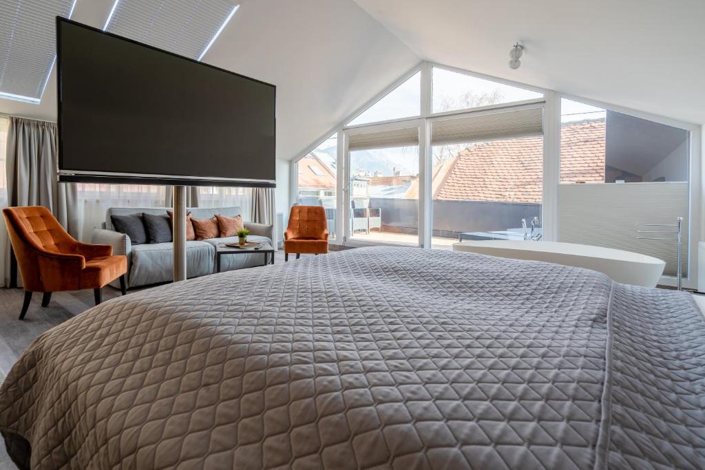 1 dormitorio con 1 cama grande y ventana grande en Kaiser Max Design Appartements, en Innsbruck