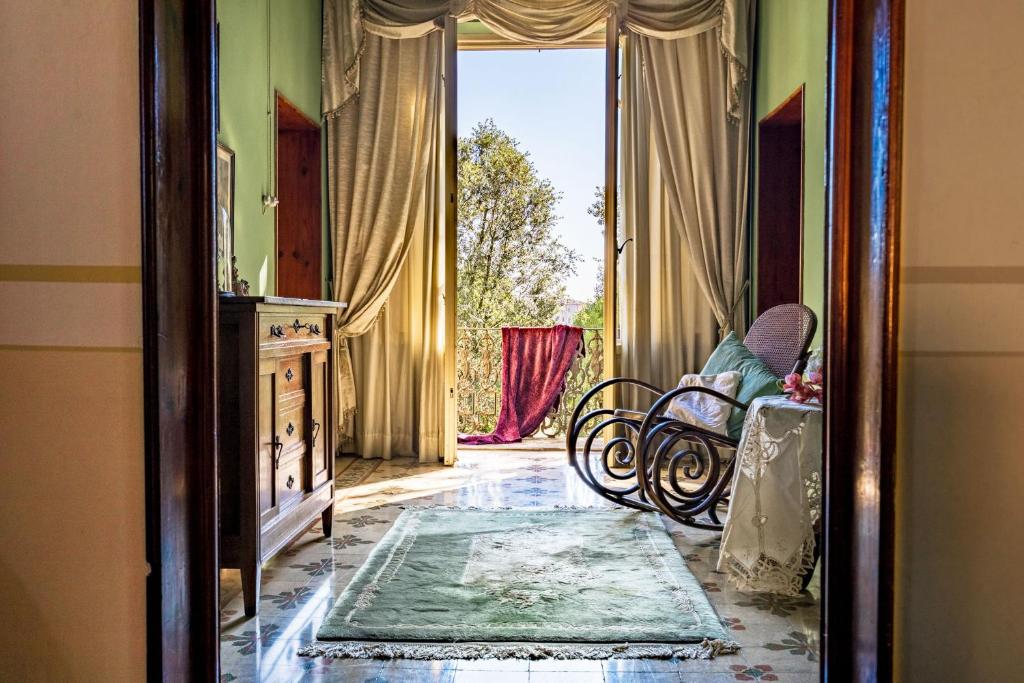 uma porta aberta para um quarto com uma cadeira num quarto em Villa Ines 19th century atmosphere near Lucca em Altopascio