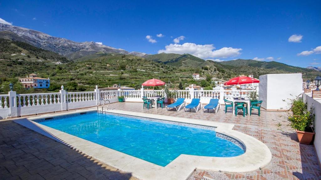 a swimming pool with a white fence and mountains at Casa Tejo Sedella by Ruralidays in Sedella