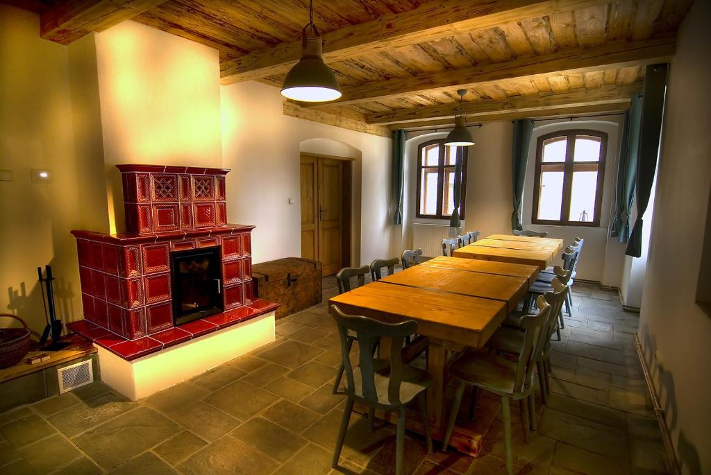 Habitación grande con mesa de madera y chimenea. en Horská chalupa Jeřabina en Horní Blatná