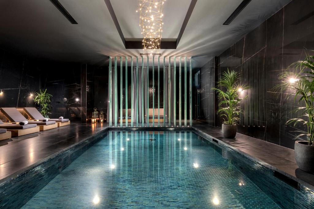 a swimming pool in a hotel with a chandelier at Lure Hotel & Spa - Adults Only in Mellieħa