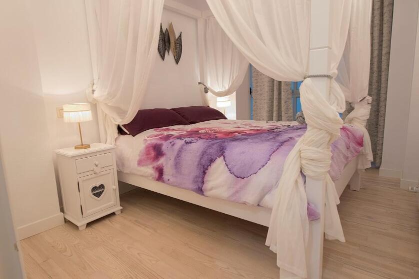 um quarto com uma cama de dossel branca em "El Rincon Apartament " em Pamplona