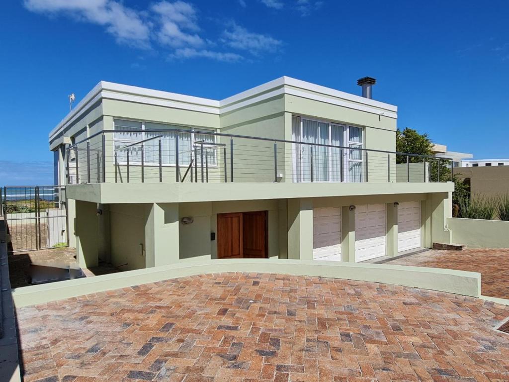 a large house with a large patio in front of it at Wilwou At Sea in Gordonʼs Bay