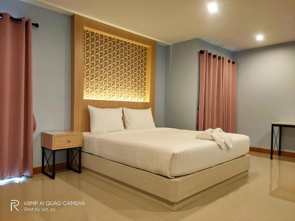 Un pat sau paturi într-o cameră la TK Thongrak Apartment
