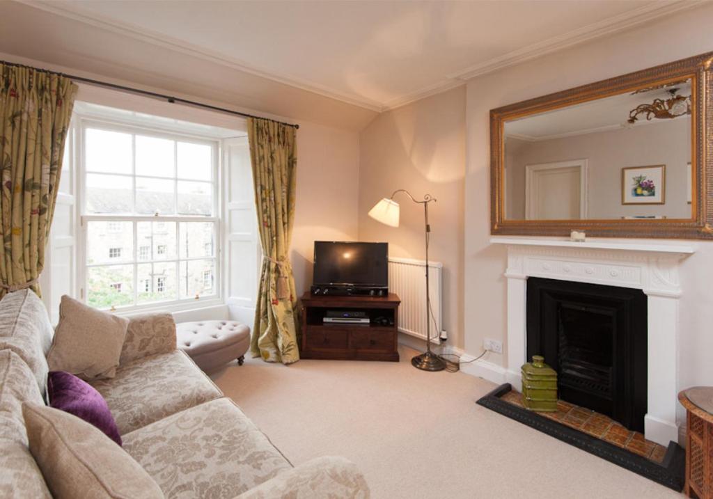 a living room with a couch and a fireplace at The Hart Street Residence in Edinburgh