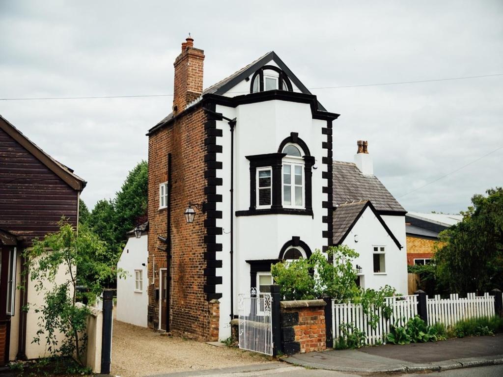 een oud wit en zwart huis met een hek bij Langs Hall in Leyland