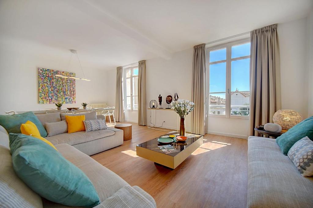 ein Wohnzimmer mit einem Sofa und einem Tisch in der Unterkunft IMMOGROOM - Magnificent 180m duplex apartment - Parking - Air conditioning in Cannes