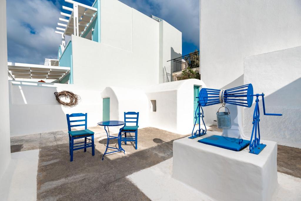 費拉的住宿－Authentic Santorinian Home Experience，一组蓝色椅子和一张桌子,位于大楼前