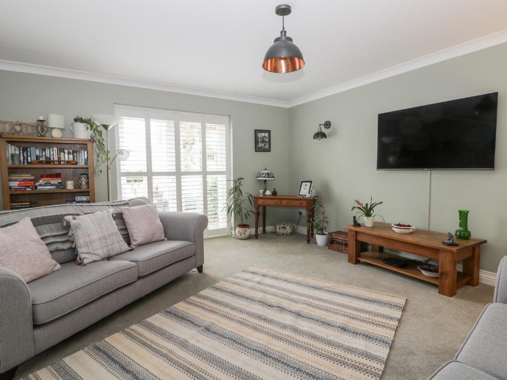 ein Wohnzimmer mit Couch und Flachbildfernseher in der Unterkunft Gabby's Garden Cottage in Hull