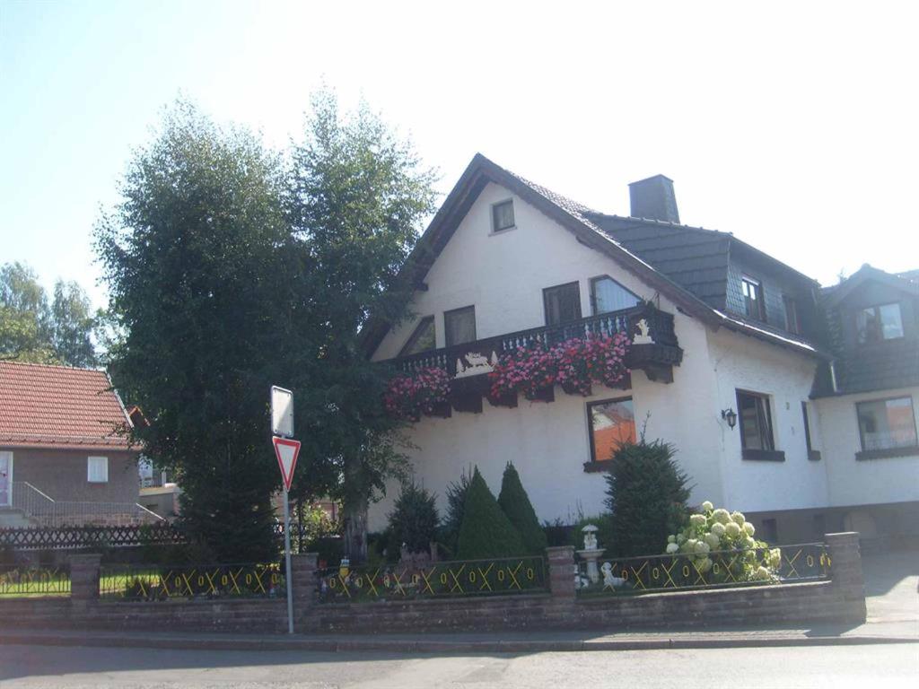 a white house with flowers on the side of it at Ferienwohnung Ellen in Ehrenberg