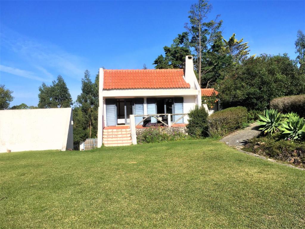 een huis met een oranje dak en een tuin bij Casa dos Pintos, Golf e Natureza in Belas