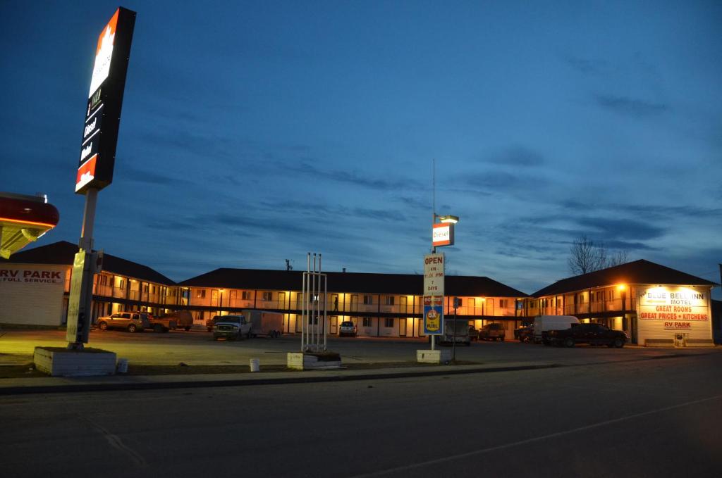 a building with cars parked in a parking lot at night at Blue Bell Inn in Fort Nelson