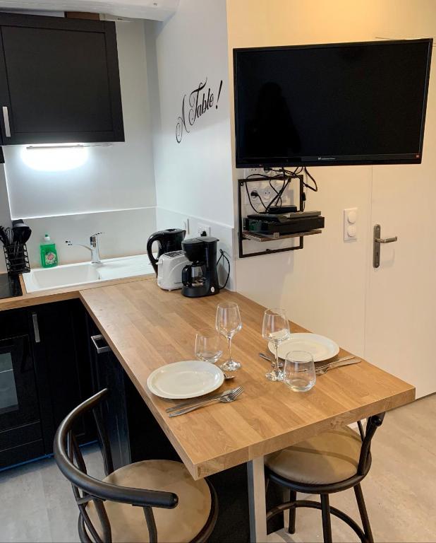 a kitchen with a wooden table with wine glasses on it at Studio centre ville -001 in Rouen