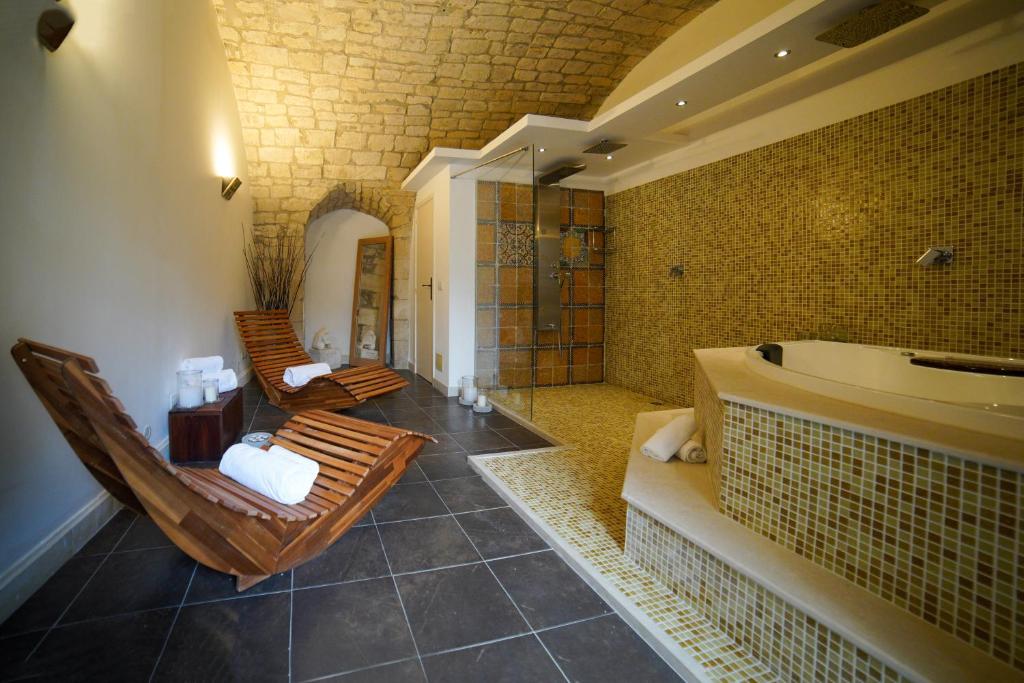 un bagno con 2 sedie e una vasca da bagno di Modica Castle a Modica