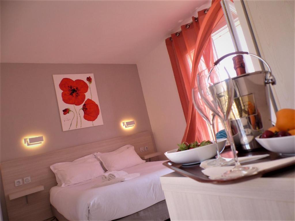 una camera d'albergo con due letti e un tavolo con frutta di Stella Marina a Macinaggio