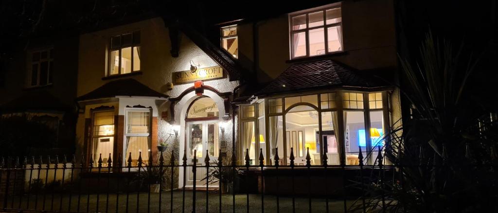 une maison avec une porte en face de celle-ci la nuit dans l'établissement Sunnycroft Private Hotel, à Llandudno