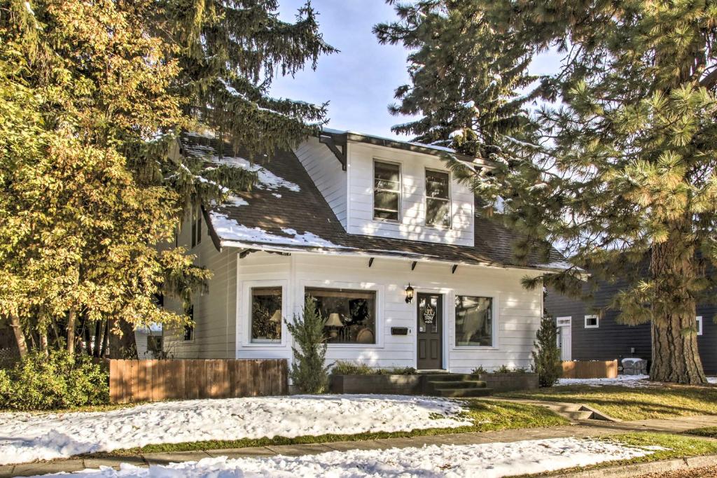 a white house with a black roof at Charming Downtown Coeur dAlene Home with Yard! in Coeur d'Alene