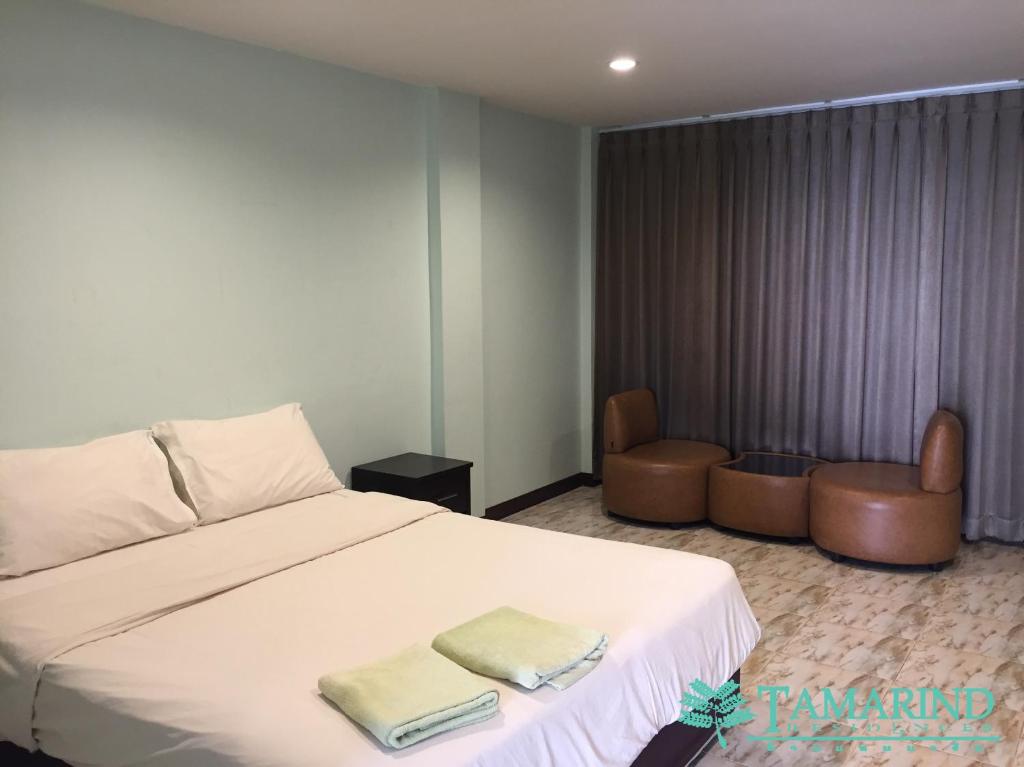 a bedroom with a bed with two towels on it at Tamarind Residences Khonkaen บ้านแทมมารีน in Khon Kaen