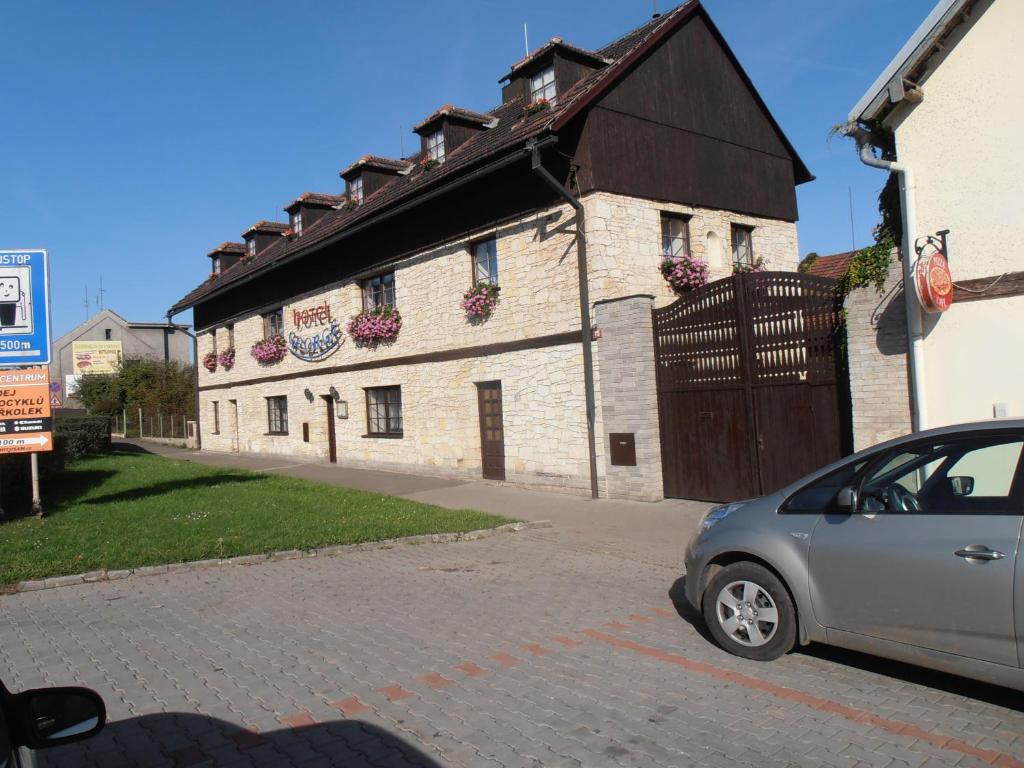 ein kleines Auto, das vor einem Gebäude geparkt ist in der Unterkunft Villa George in Řevničov