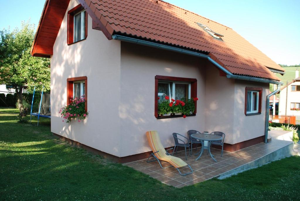 a small white house with a table and chairs at Aniel Privat in Bobrovec