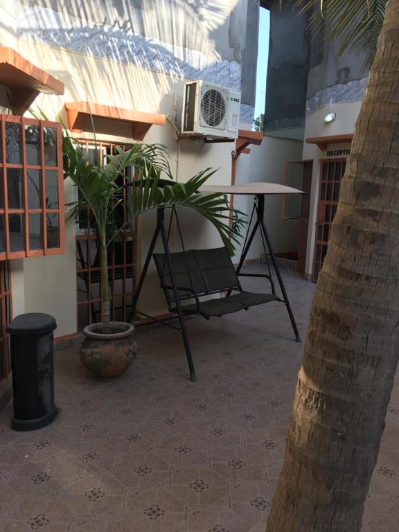 eine Terrasse mit einem Tisch, einem Stuhl und einer Pflanze in der Unterkunft Sumanguru Guest House- GATEWAY TO THE AIRPORT in Busumbala