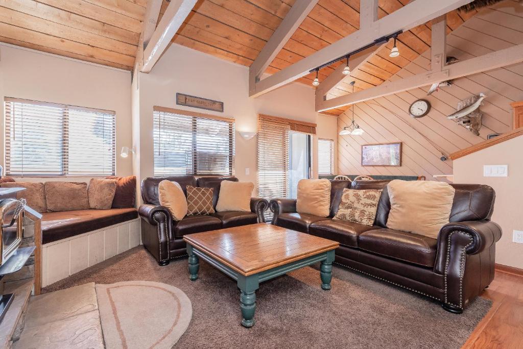 sala de estar con muebles de cuero y mesa en Bigwood W #90, en Mammoth Lakes