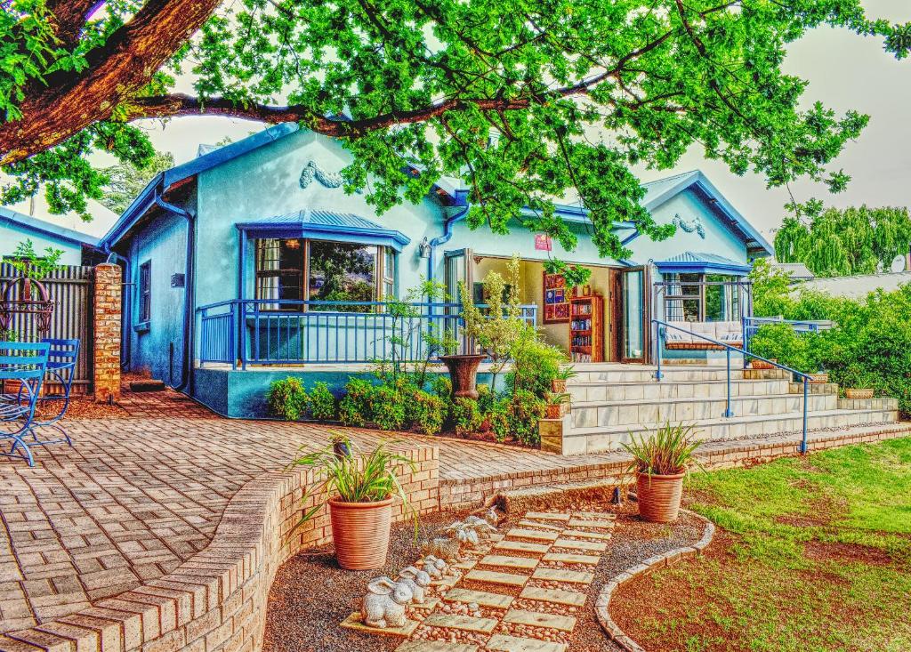 niebieski dom z ceglanym patio przed nim w obiekcie Golden View - Oak on Church w mieście Clarens