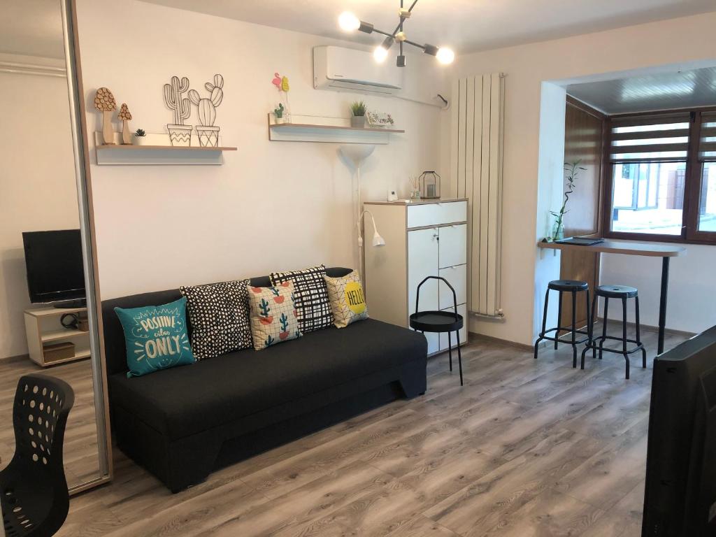 ein Wohnzimmer mit einem Sofa und einer Küche in der Unterkunft Cozy Place 5a-Self Check in & out-HBO MAX in Piteşti