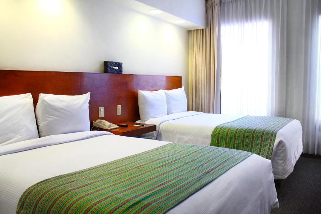 Postel nebo postele na pokoji v ubytování Hotel Alameda Centro Historico