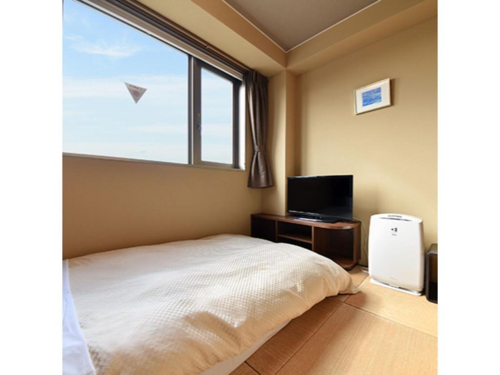 1 dormitorio con 1 cama, TV y ventana en HOTEL FUTABATEI - Vacation STAY 03242v, en Kido