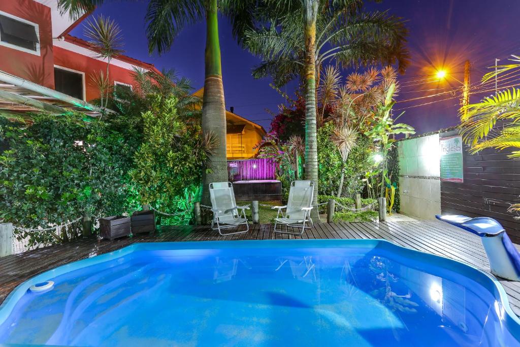 una bañera de hidromasaje en un patio trasero con mesa y sillas en Pousada Praia dos Ingleses, en Florianópolis