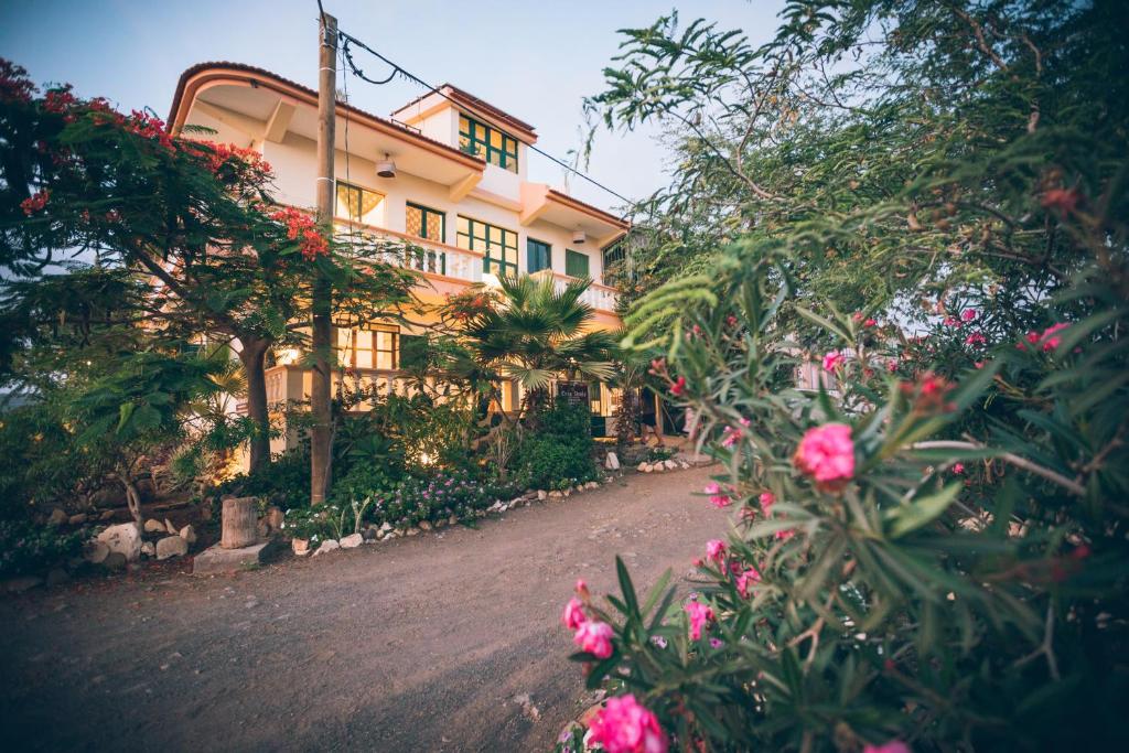 ein Haus mit rosa Blumen davor in der Unterkunft Casa Strela B&B Tarrafal in Tarrafal