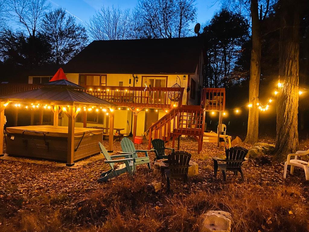 a backyard with a gazebo and chairs and lights at Luxurious house with largest hot tub & perfect retreat! in Lake Harmony