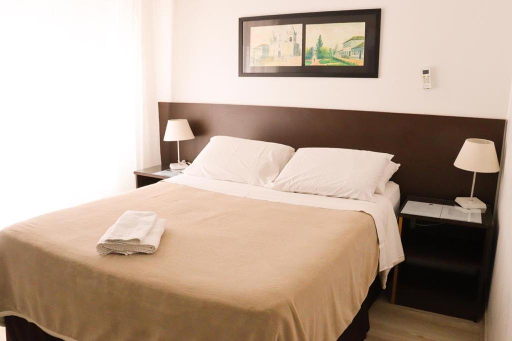 a bedroom with a large bed with a brown headboard at Veneto Hotel in Canguçu
