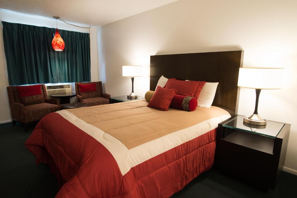 a bedroom with a large bed with red pillows at Cougar Land Motel in Pullman