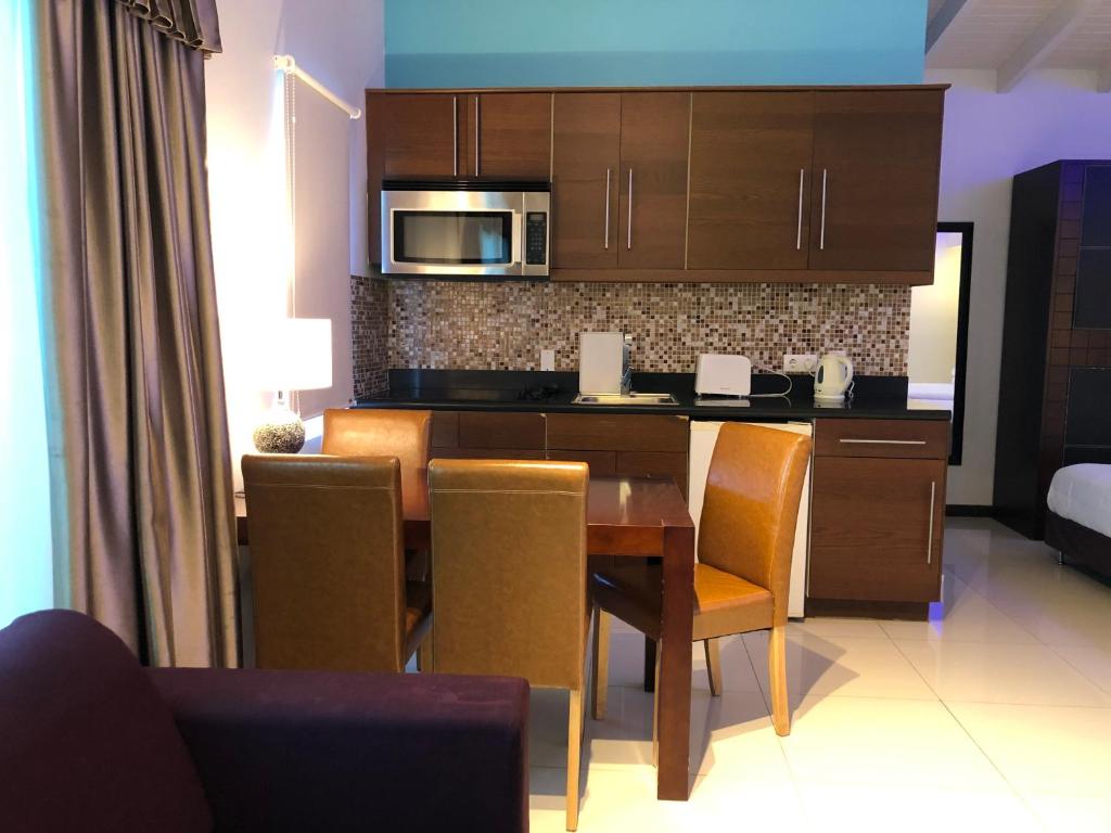 a kitchen with a table with chairs and a microwave at Quints Travelers Inn in Willemstad