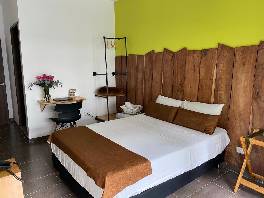 a bedroom with a large bed with a wooden headboard at Rivière Boutique Hotel in Medellín