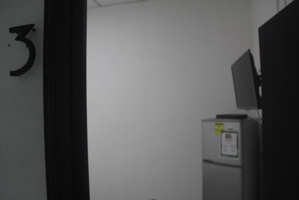 a refrigerator with a television on top of it at Eden`s Garden Hostel in Panama City