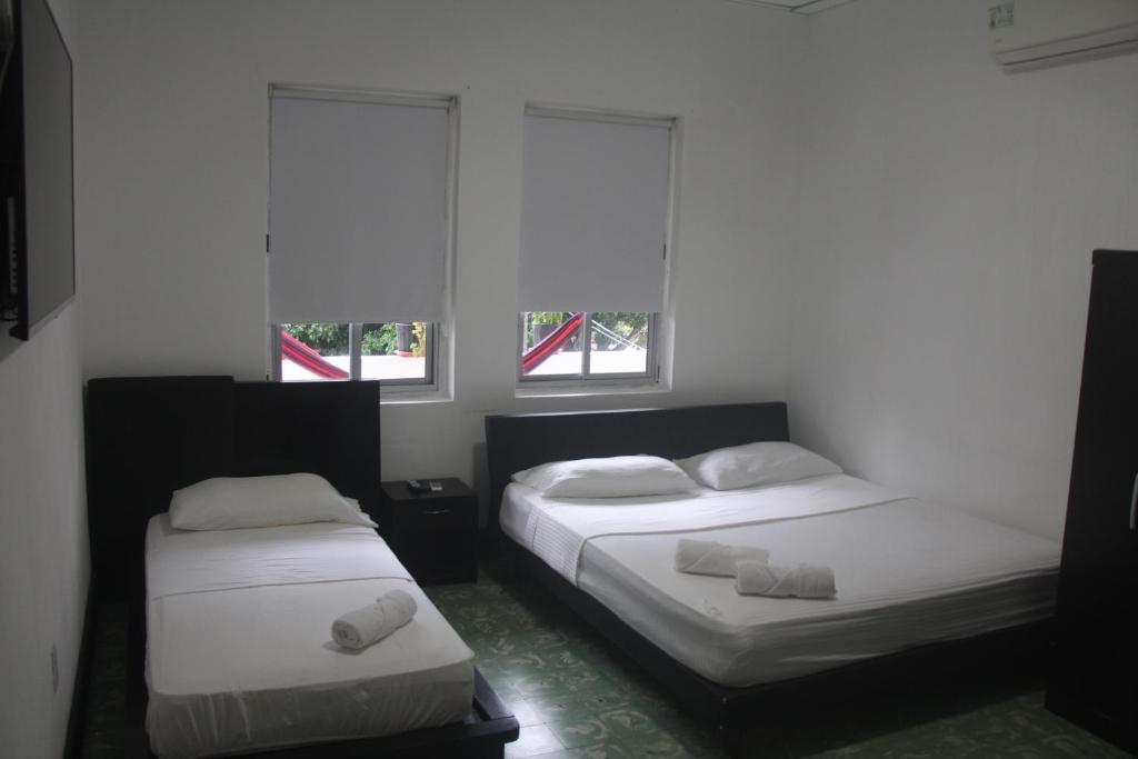two beds in a room with two windows at Eden`s Garden Hostel in Panama City
