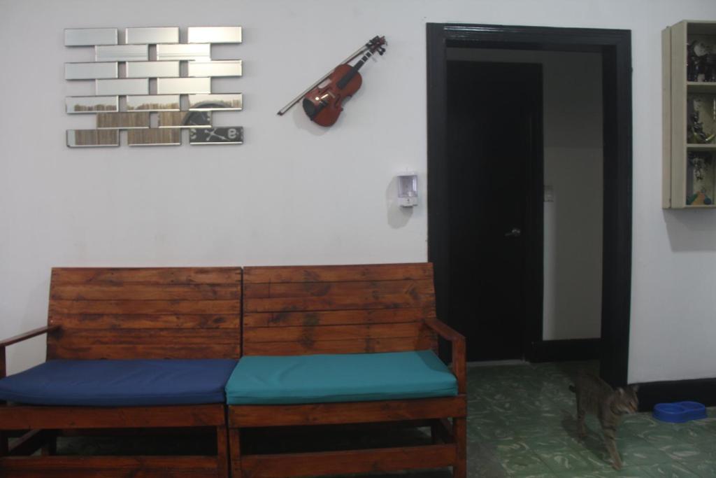 a room with a bench and a guitar on the wall at Eden`s Garden Hostel in Panama City