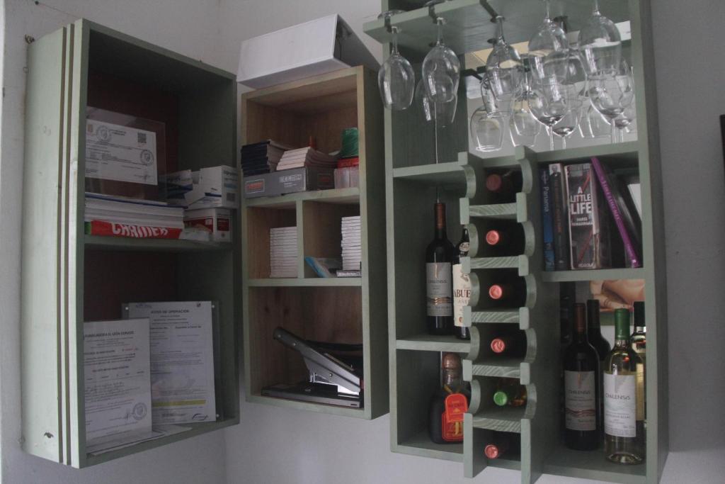 a cabinet with wine bottles and glasses on it at Eden`s Garden Hostel in Panama City