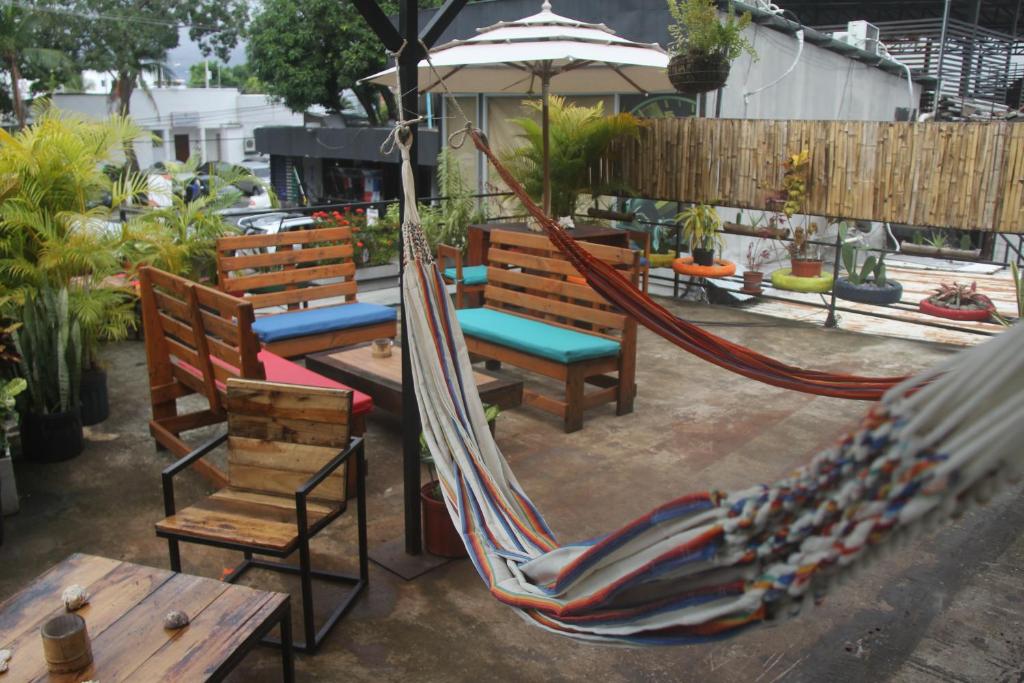a group of chairs and hammocks on a patio at Eden`s Garden Hostel in Panama City