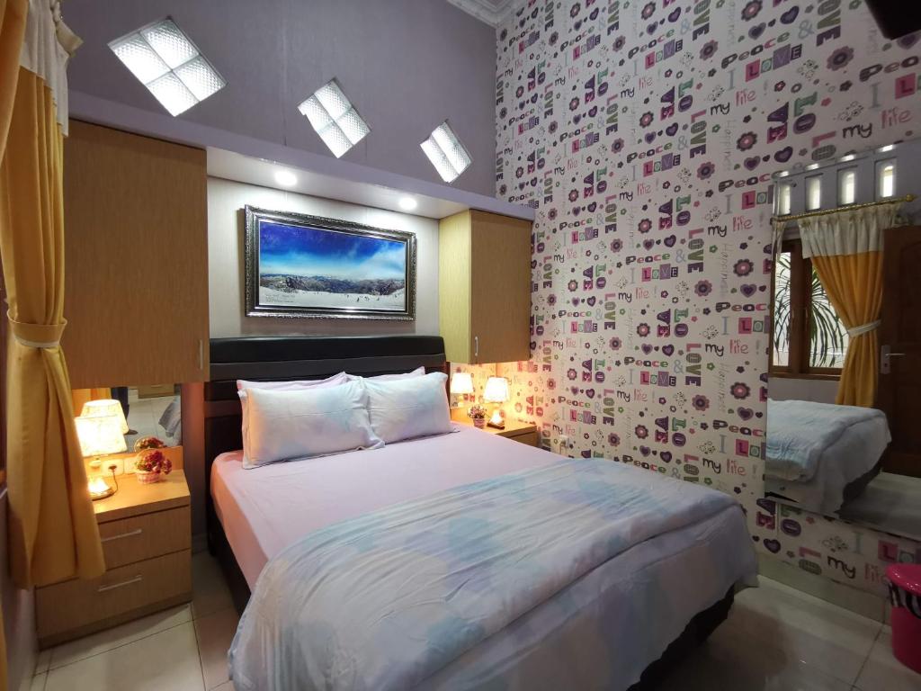 a bedroom with a bed and a wall with flowers at Nariska Suite Homestay in Yogyakarta