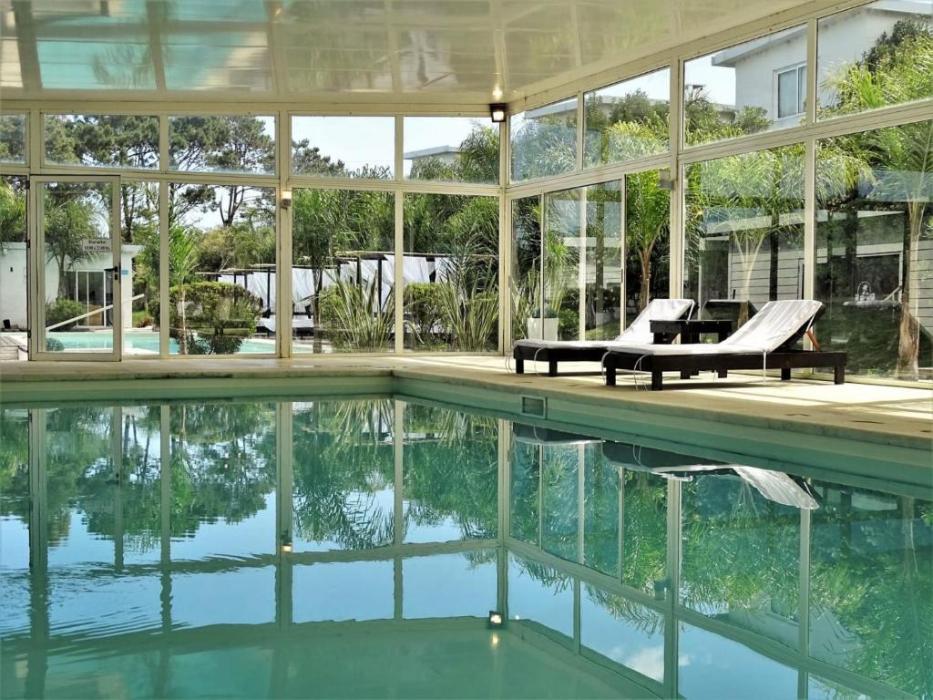 eine Außenansicht eines Hauses mit Pool in der Unterkunft Skyblue Apart Hotel Punta Colorada in Piriápolis