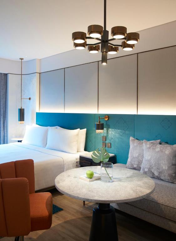 a bedroom with a bed and a table and a couch at Amari Bangkok in Bangkok