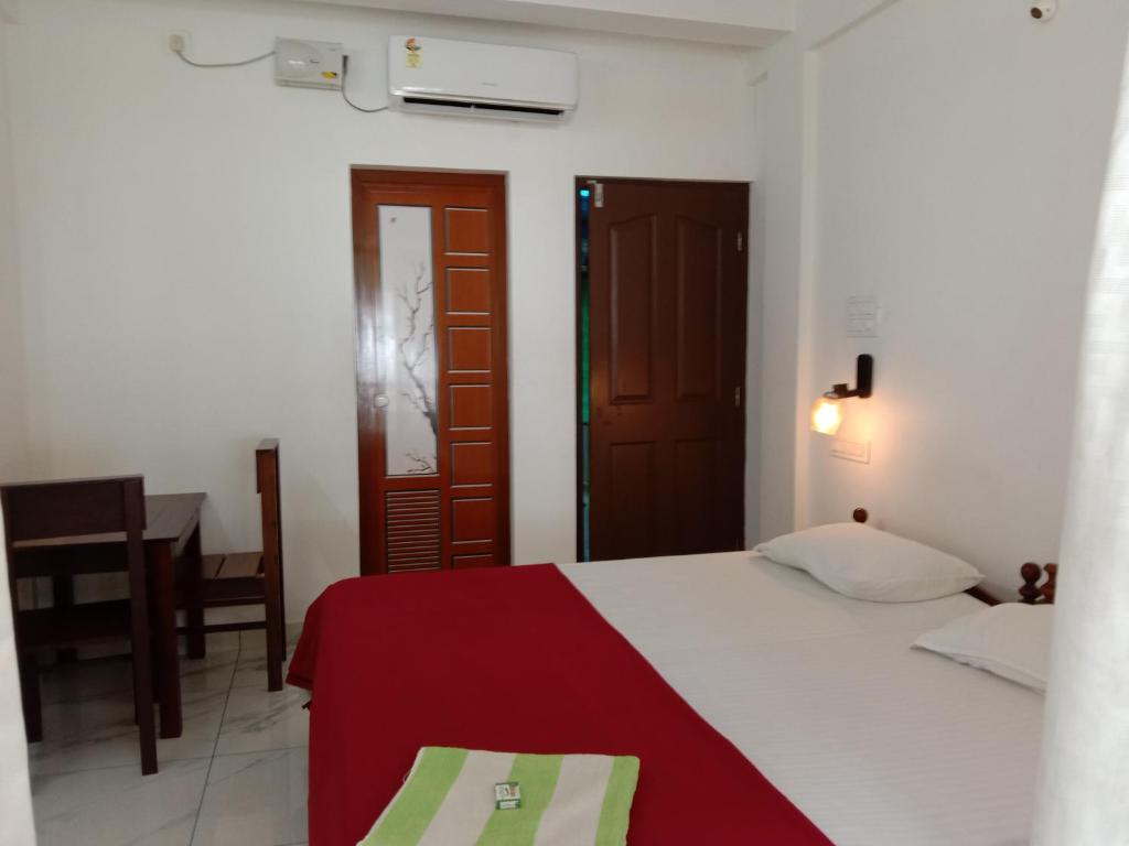 a bedroom with a bed with a red blanket at Cherai Ocean View Home in Cherai Beach