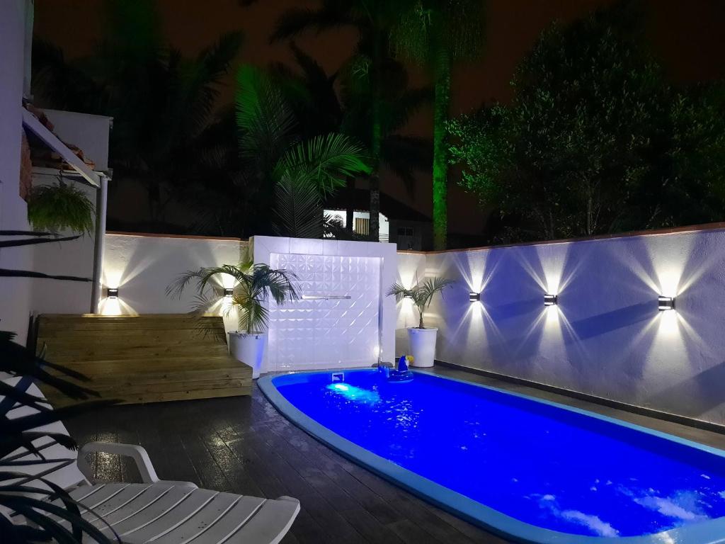 uma piscina num quintal à noite em Triplex Aconchego em Itapoá