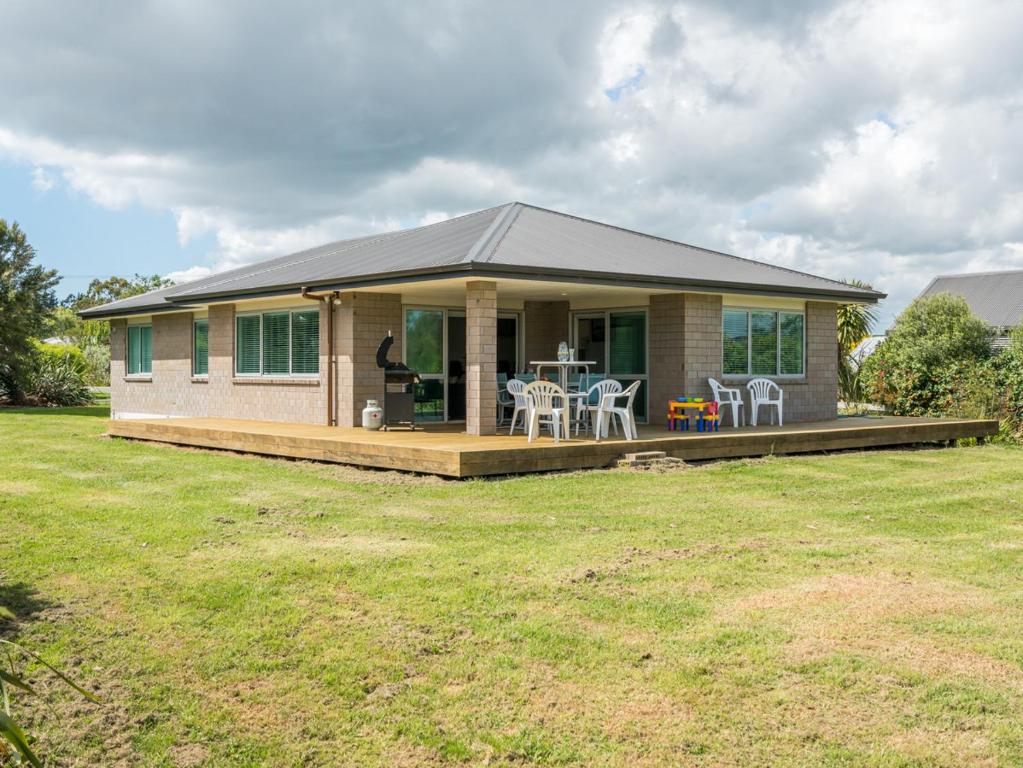 uma pequena casa com um alpendre e um deque em Millies Place - Mangawhai Holiday Home em Mangawhai