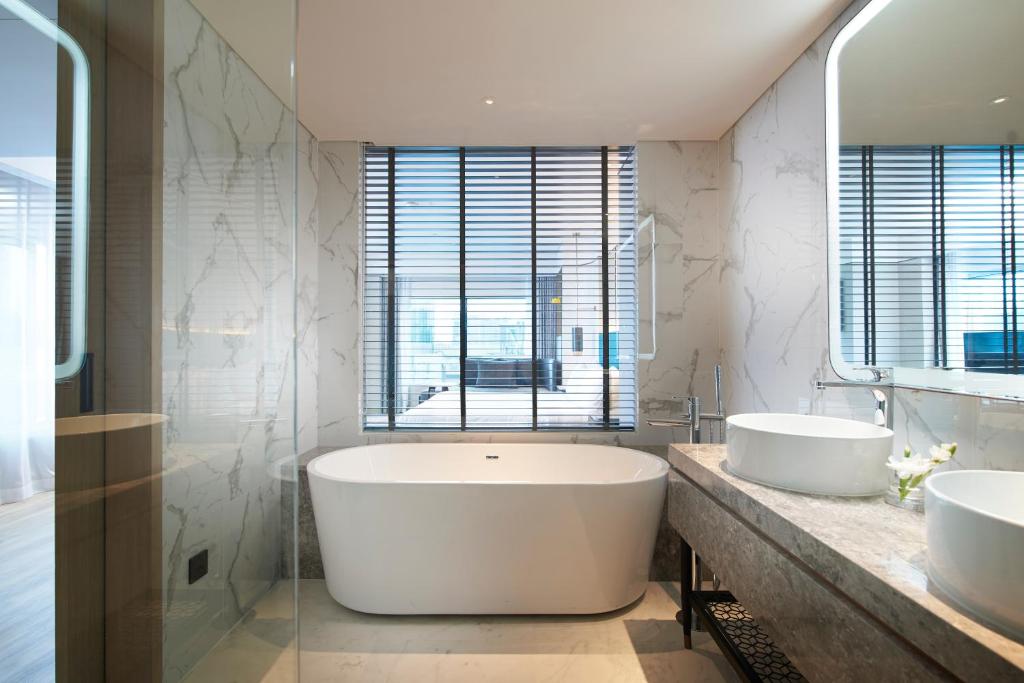 a bathroom with two sinks and a large tub at Amari Bangkok in Bangkok